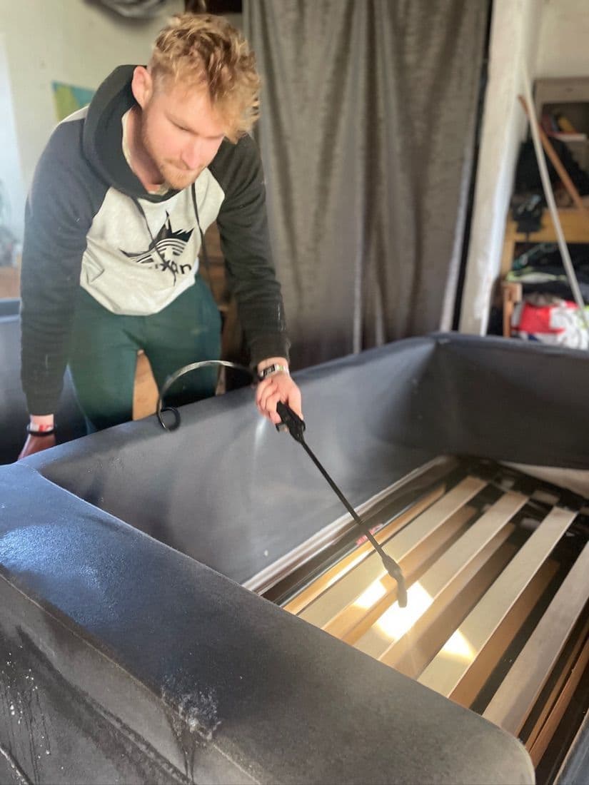 Technicien Happy Propre pulvérisant un produit sur un canapé-lit en velours gris