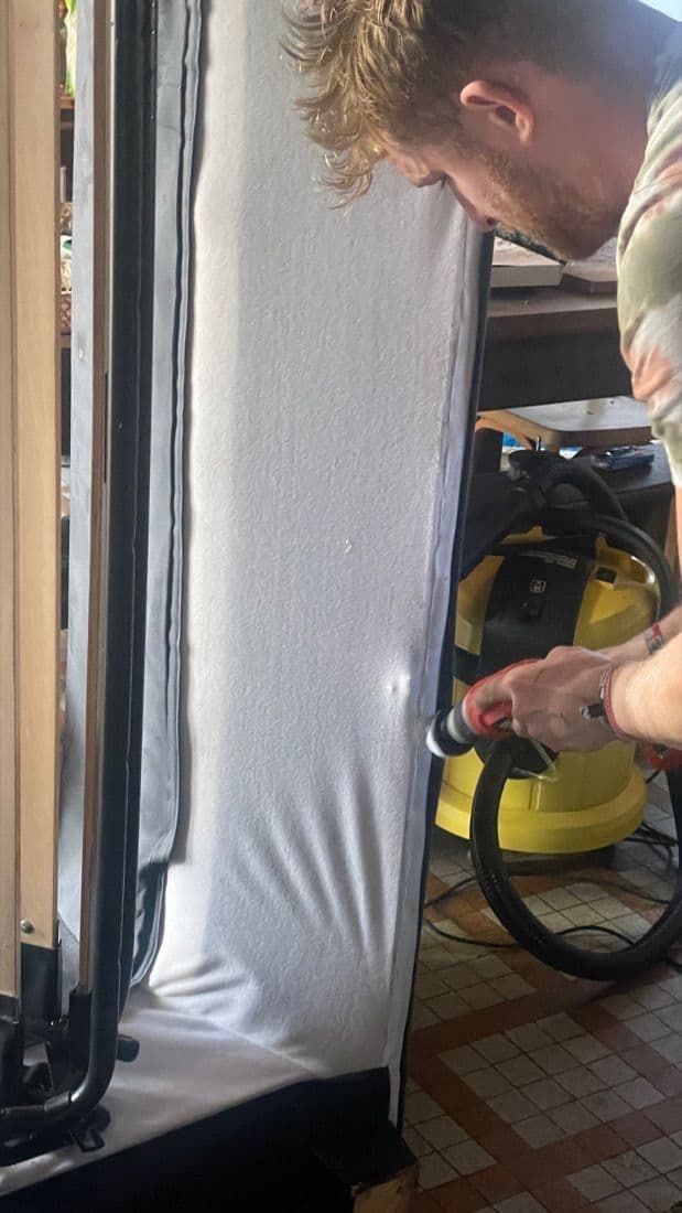 Technicien Happy Propre brossant un matelas avec un aspirateur-nettoyeur