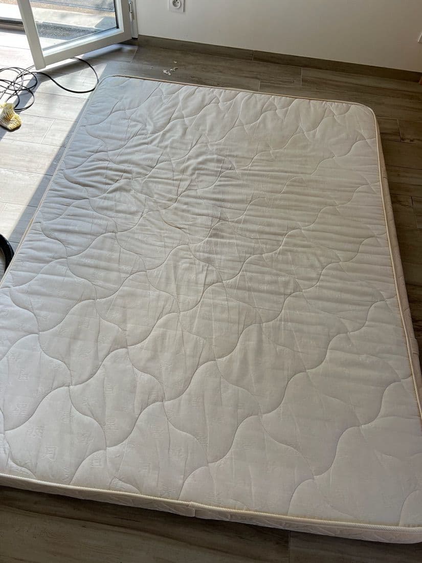 Matelas blanc avec une grande tache sombre avant nettoyage, puis propre après — après